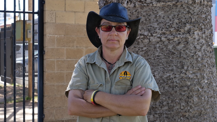 A woman in wildlife carer uniform with arms crossed.