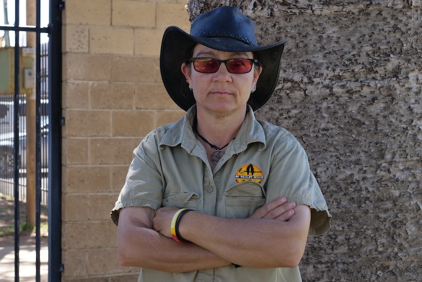 A woman in wildlife carer uniform with arms crossed.