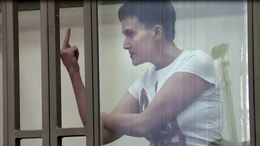 Nadiya Savchenko shows her middle finger to a Russian court from inside the witness box.