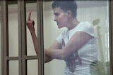 Nadiya Savchenko shows her middle finger to a Russian court from inside the witness box.