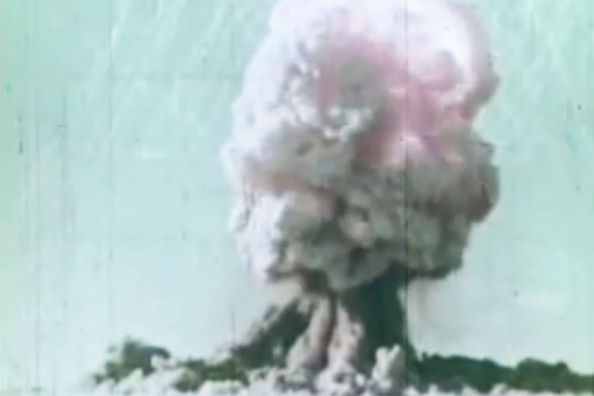 An old shot of a large mushroom cloud billowing into the air.