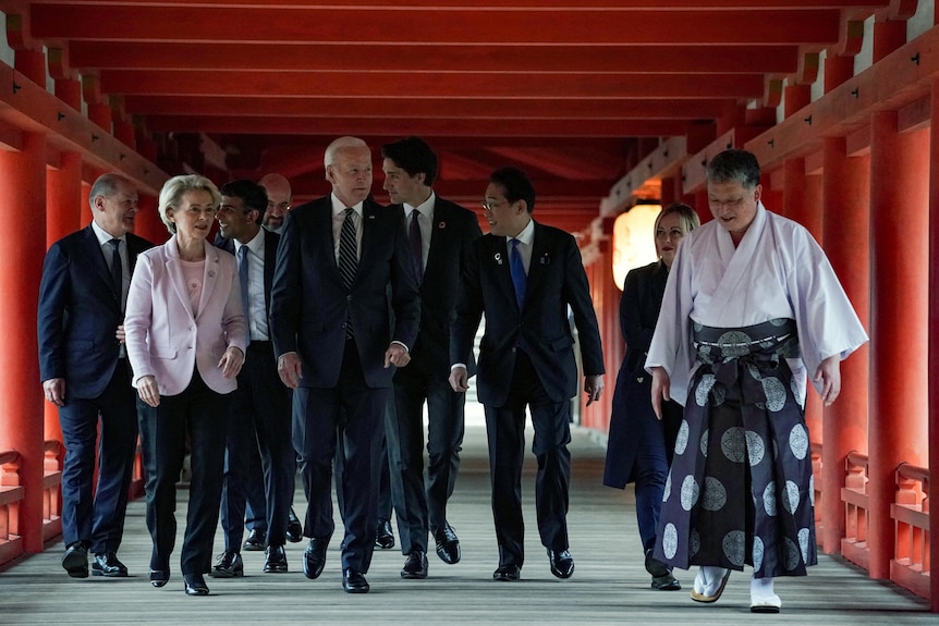 G7 leaders walk together through Japanese shrine.