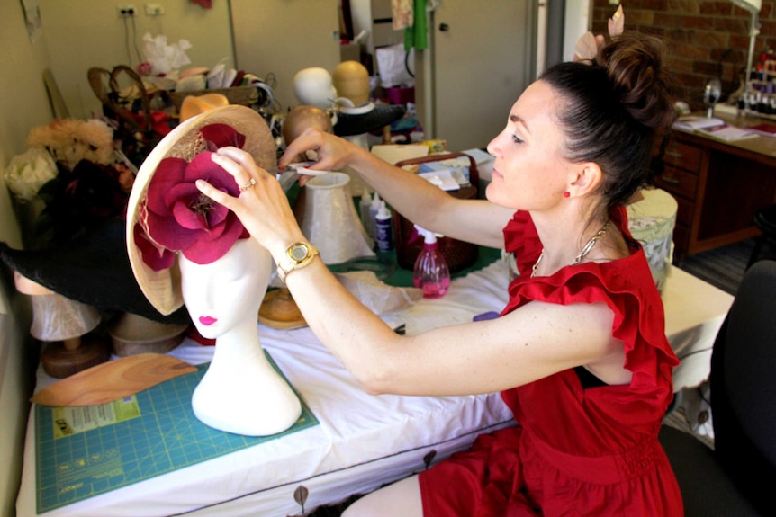 Julia Watson puts the finishing touches on a headpiece at home in Yeppoon