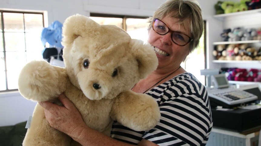 Alison Shaw is holding up a honey coloured Tambo Teddy