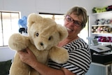 Alison Shaw is holding up a honey coloured Tambo Teddy