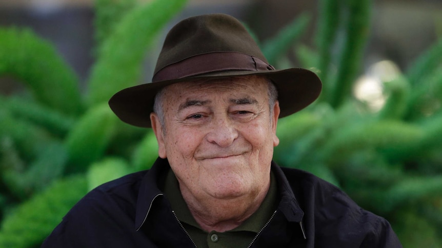 Smiling older man with a hat on.