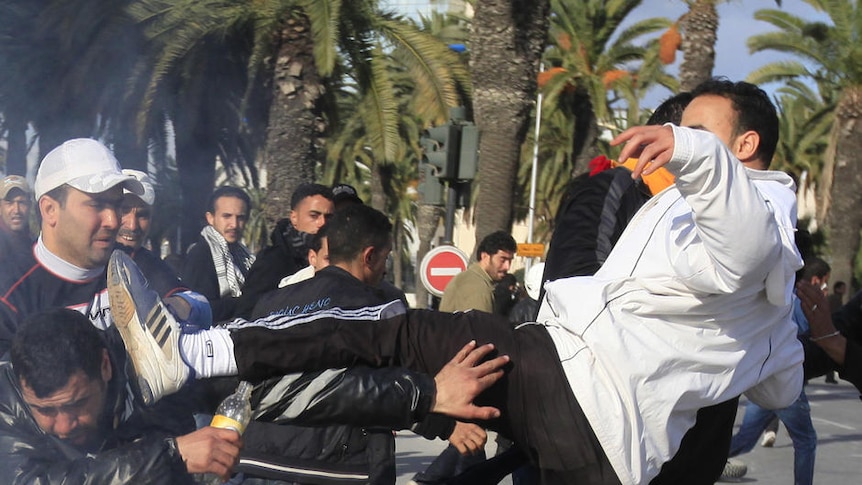 Protesters clash with police in political riots that erupted in the capital Tunis