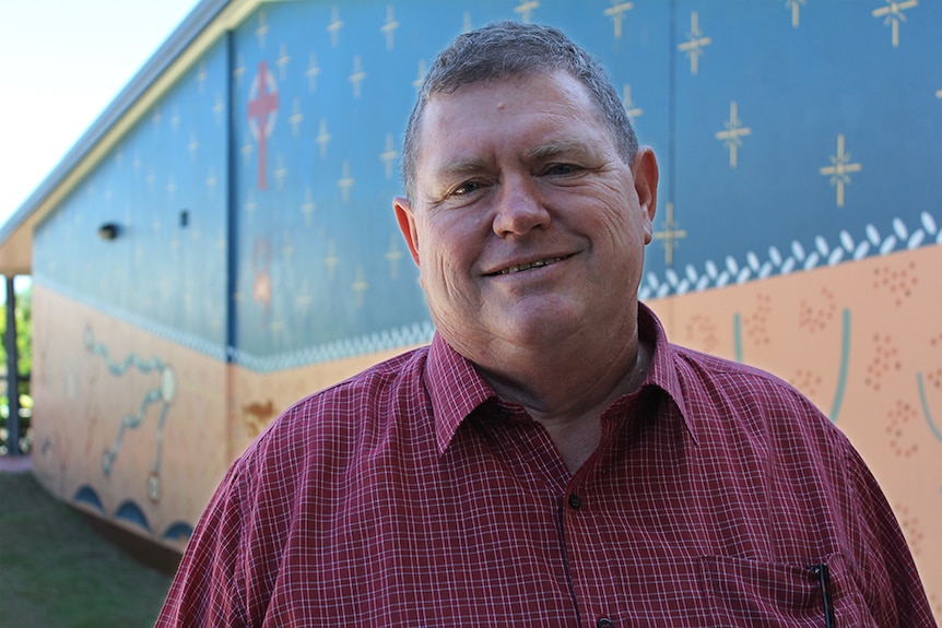 Reverend Murray Fysh standing in front of a mural at the Merthyr Road Uniting Church in New Farm.