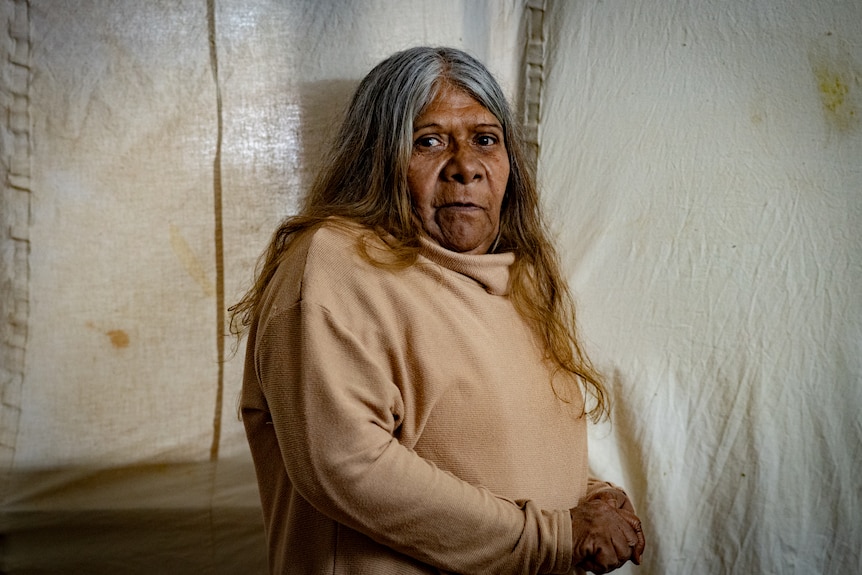 An aboriginal woman looking pensively at the camera