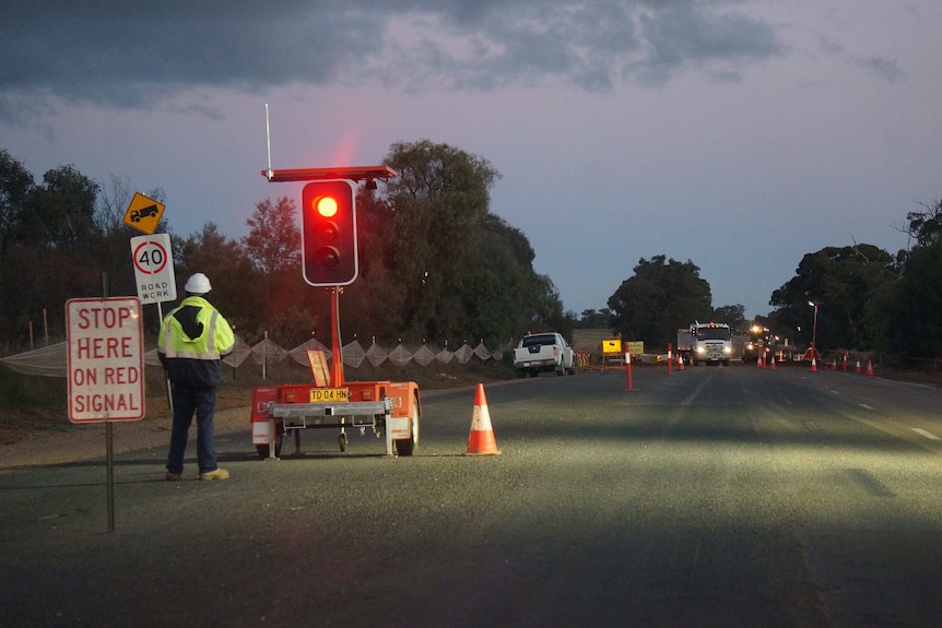 A traffic light at road works on a section of the Newell Highway at dusk.