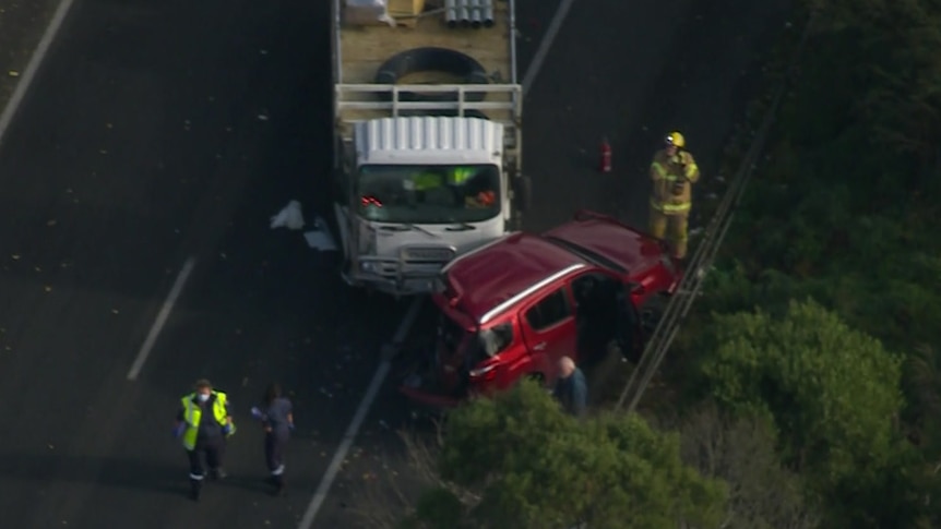 Emergency services working on a highway where a truck and car have collided
