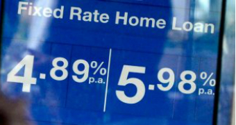 Home loan interest rates advertised on a sign outside a bank.