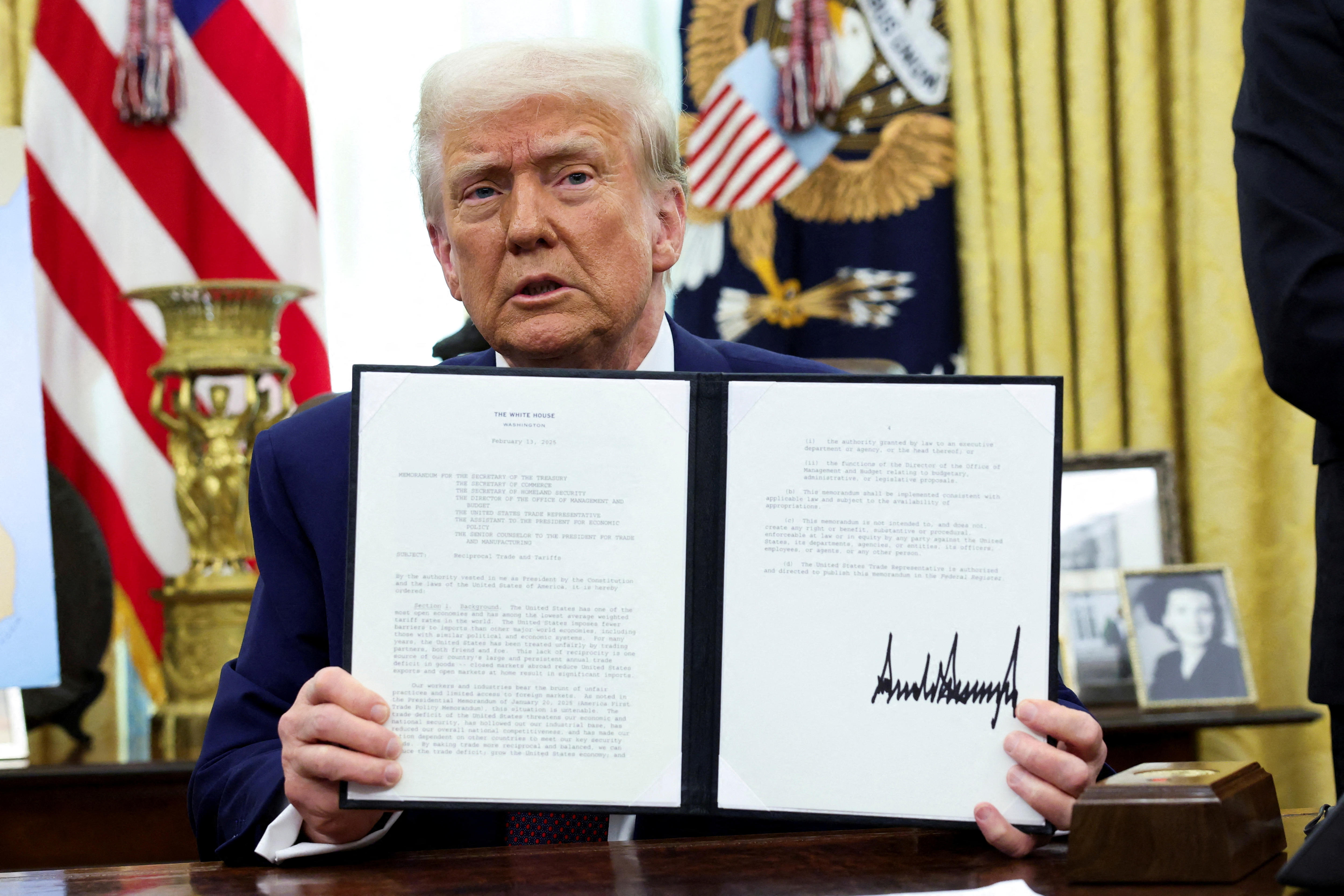 us president donald trump holds a signed executive order for tariffs increase
