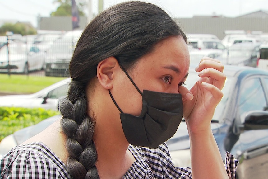 a young woman crying and wiping her eyes