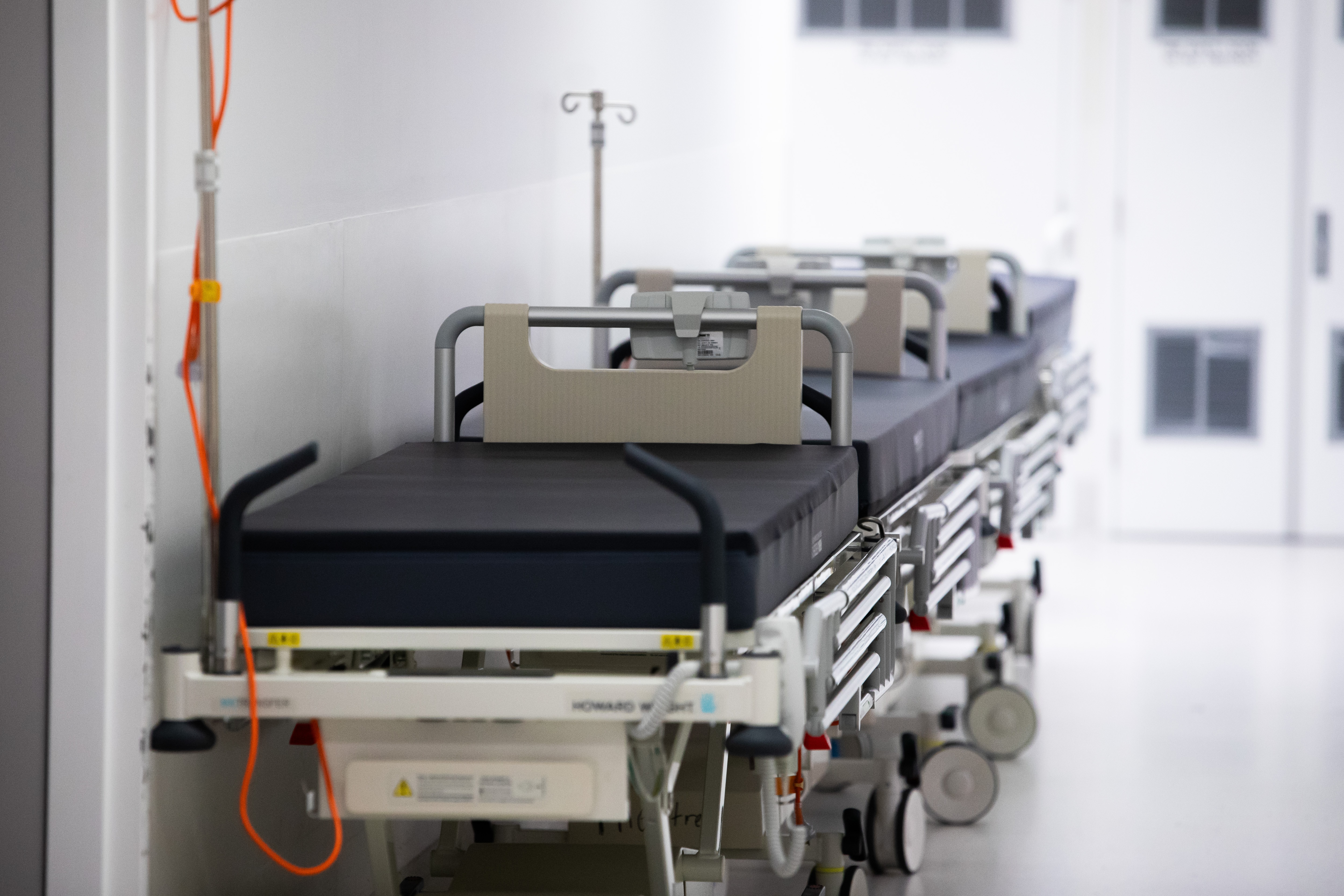 Hay camas de hospital en un pasillo.