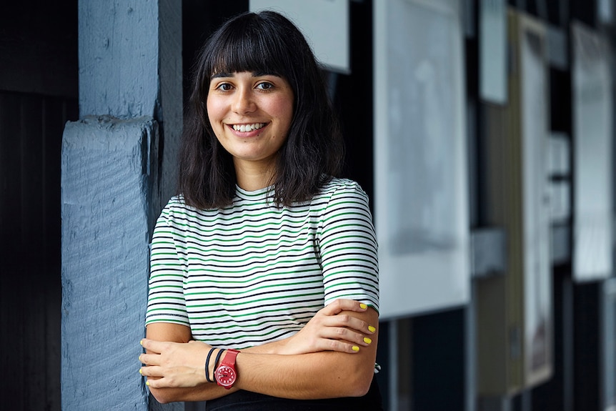 Colour photo of Jessica Arthur smiling and leaning against wall at Sydney Theatre Company.