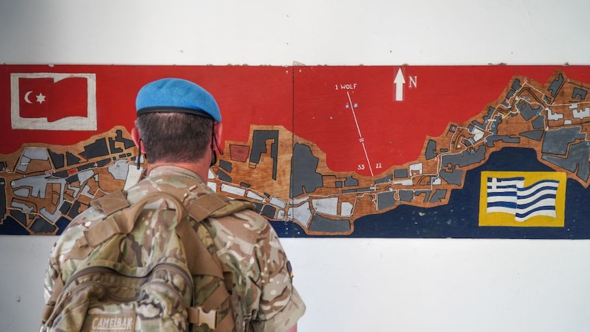 A member of the UN Peacekeeping Force in Cyprus looks at a map of the buffer zone that separates North and South Cyprus.