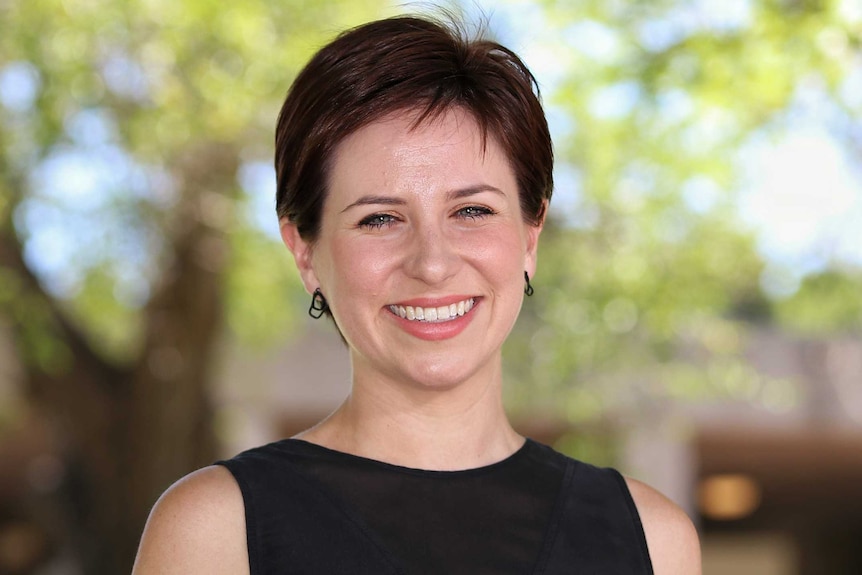 A headshot of a woman in a black top.