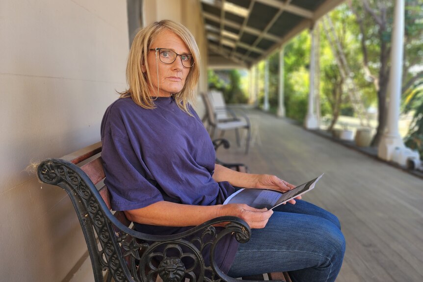 A lady sitting on a porch with documents