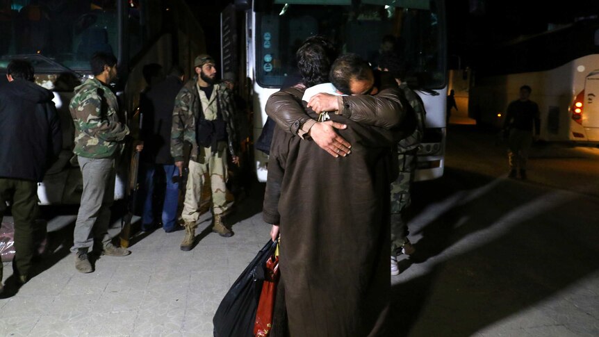 People who have evacuated from Madaya embrace as they arrive at insurgent-held Idlib city.