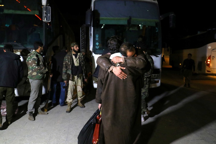 People who have evacuated from Madaya embrace as they arrive at insurgent-held Idlib city.