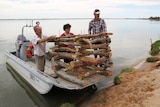 three men stand on a boat with wooden structure