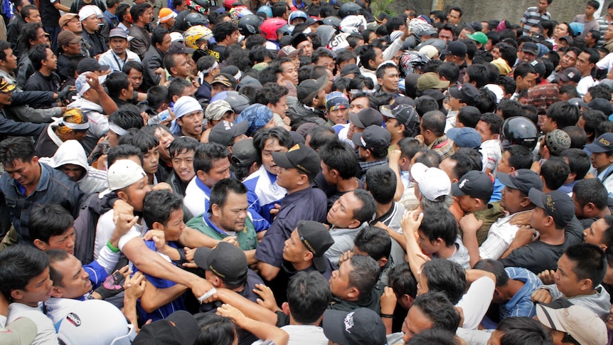 Protestors clash with company security personnel outside the Panarub Dwikarya factory in Tangerang, on October 18, 2012.