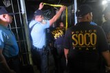 Philippines forensics team moves through yellow tape