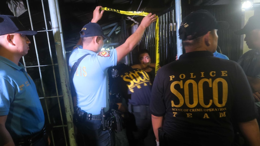 Philippines forensics team moves through yellow tape