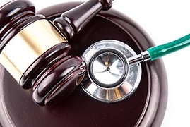 a gavel and stethoscope sitting on a white table