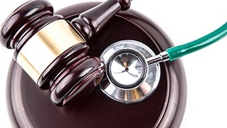 a gavel and stethoscope sitting on a white table