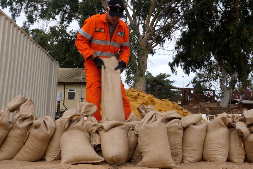 An emergency worker fills sandbags