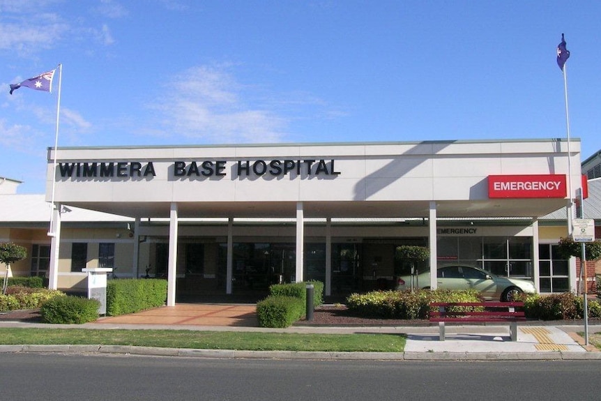 A modern building with Wimmera base Hospital written on it, against a blue sky