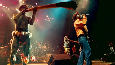 Colourful photo of a band Yothu Yindi performing live on stage