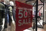 A sign saying 50 per cent off sale at a clothes shop