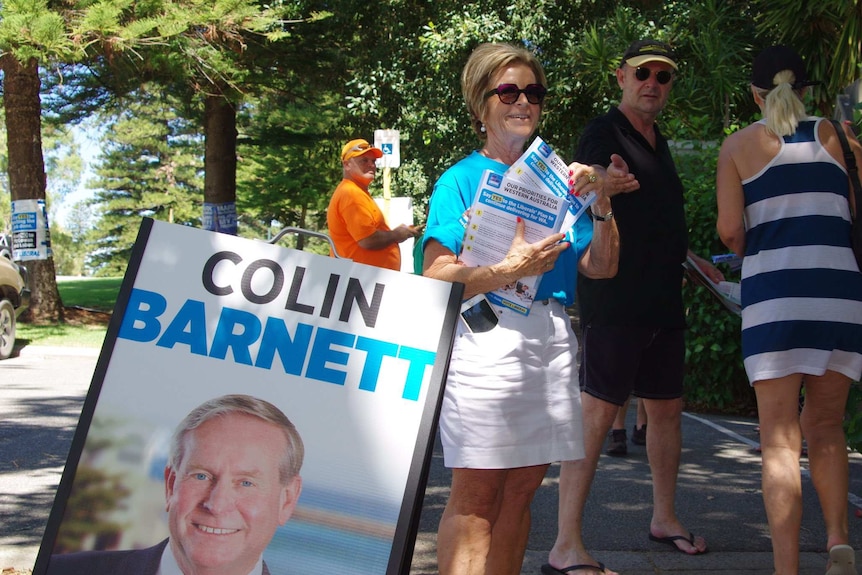 Women in blue shirt hands out voting cards