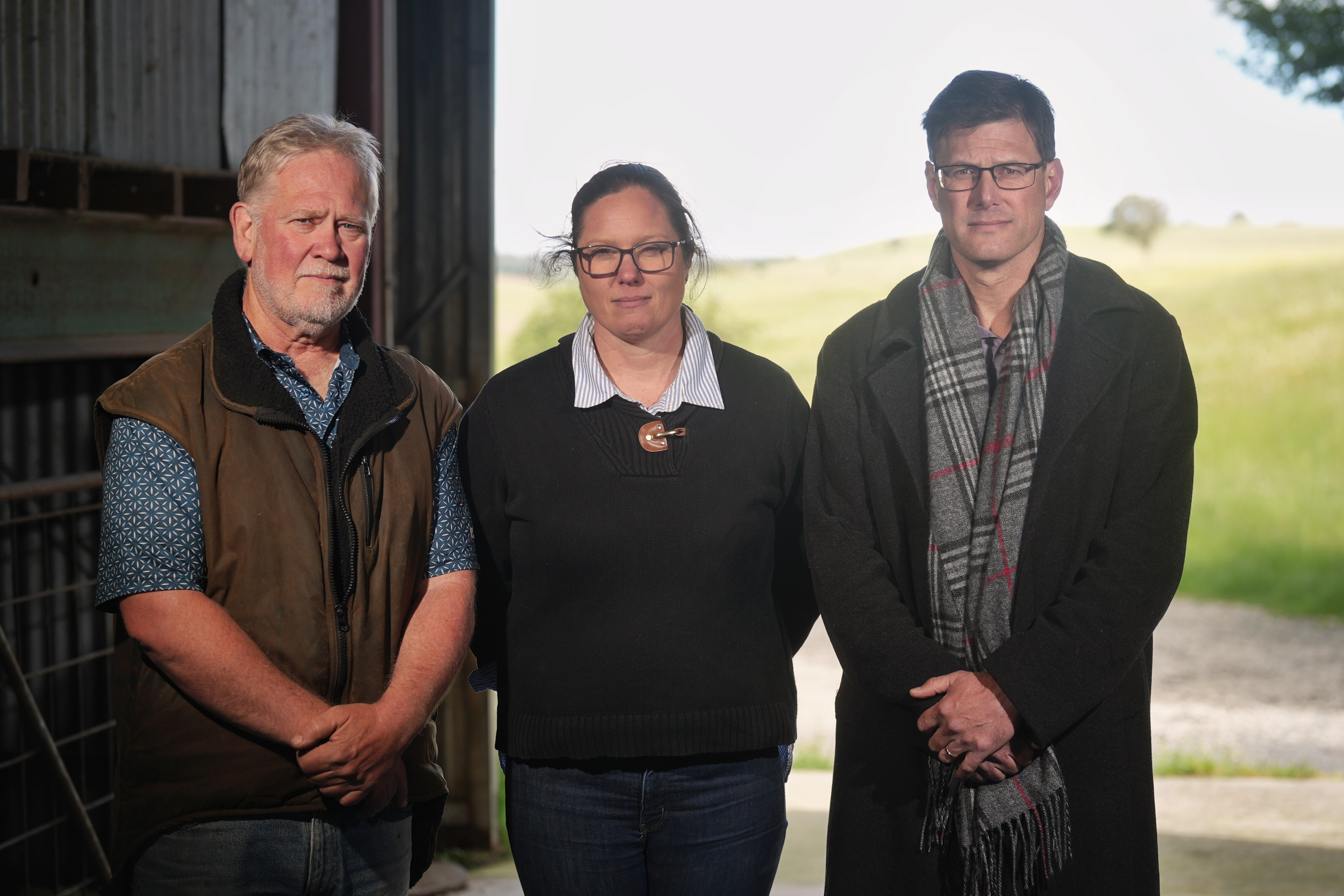 Dos hombres y una mujer están en un cobertizo. 