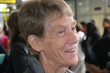 Patricia Fox smiles as she stands in the arrivals area at Melbourne Airport.