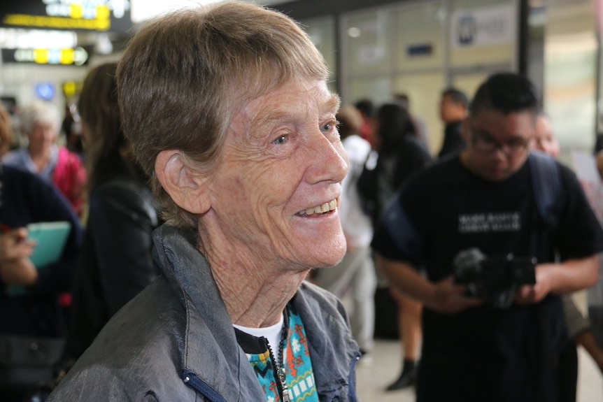 Patricia Fox smiles as she stands in the arrivals area at Melbourne Airport.