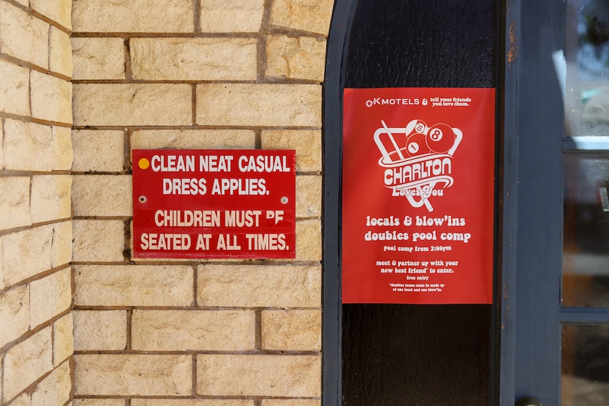 Two signs on a brick wall relating to dress code and children's safety