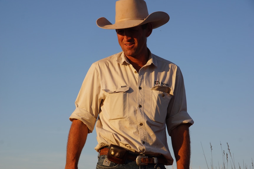 Photo of a man in an akubra against a blue sky.