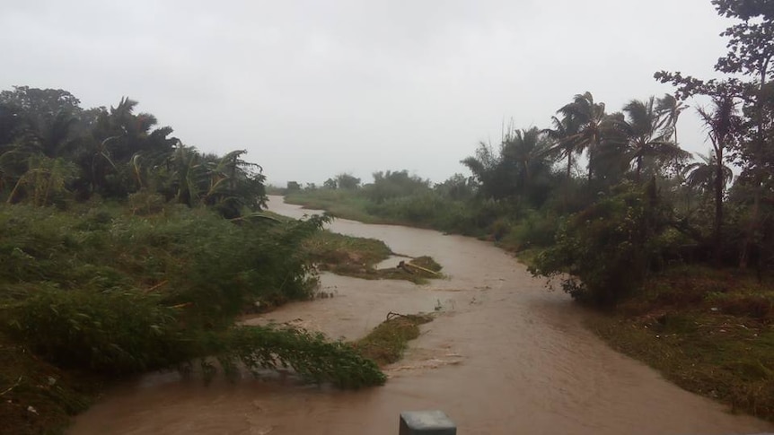 The view of a muddy river in Vanuatu from a bridge already damaged by Cyclone Pam.