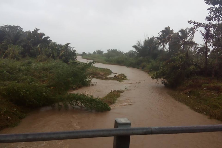 The view of a muddy river in Vanuatu from a bridge already damaged by Cyclone Pam.