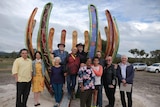 A group of people in front of a sculpture