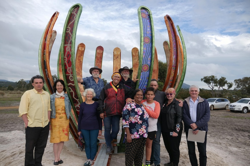 A group of people in front of a sculpture