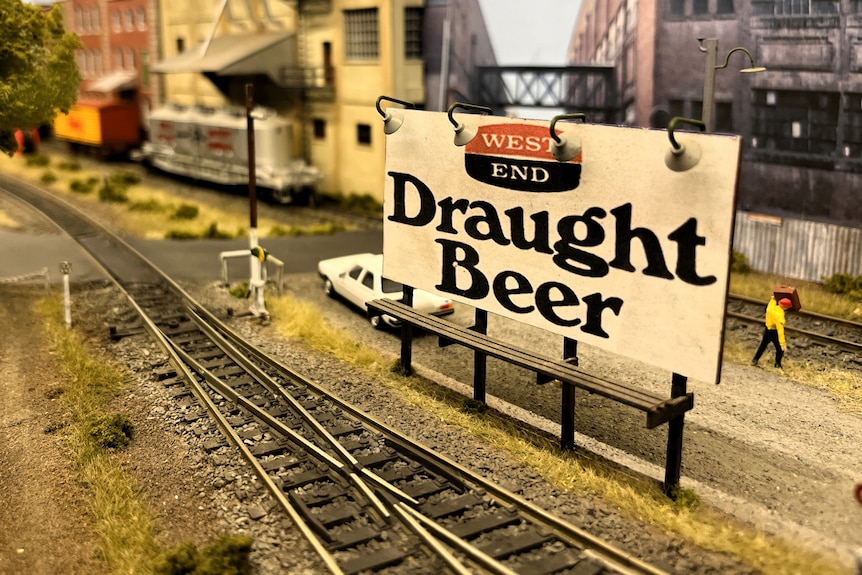 A tiny billboard advertising beer on a model railway