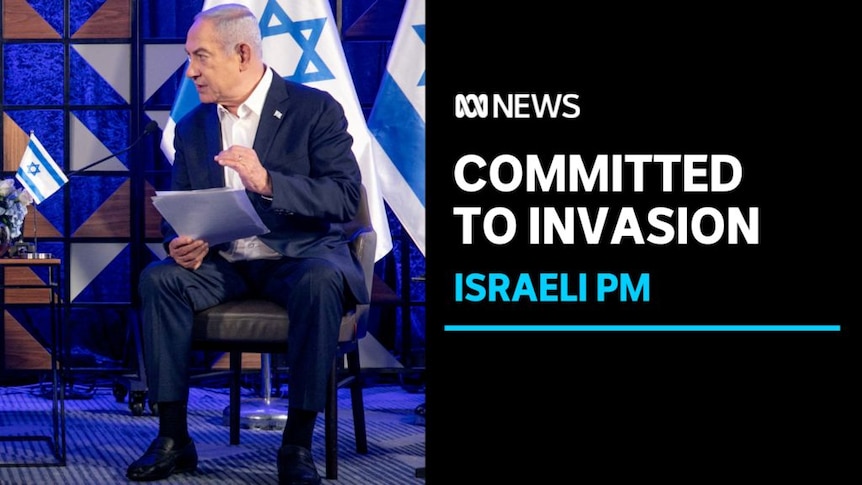 Committed to Invasion, Israeli PM: Benjamin Netanyahu speaks while on stage, holding documents. Israeli flags are behind him.