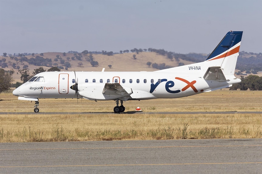 A small passenger aircraft on a runway at a country airport.