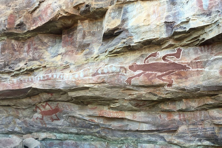 Indigenous rock art showing lizards and figures.