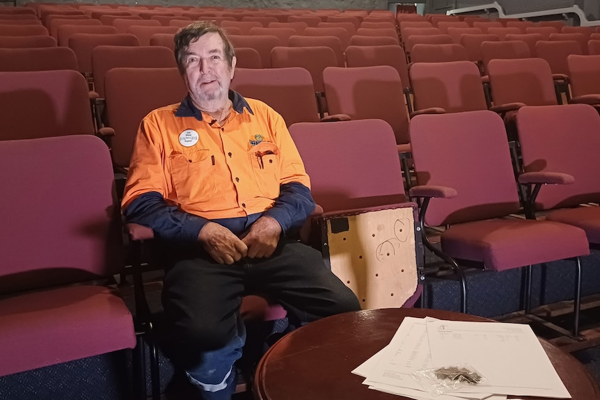 Photo d'un homme assis sur un siège de théâtre